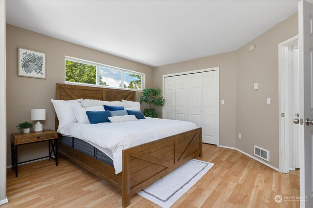 bedroom with light hardwood / wood-style floors and a closet