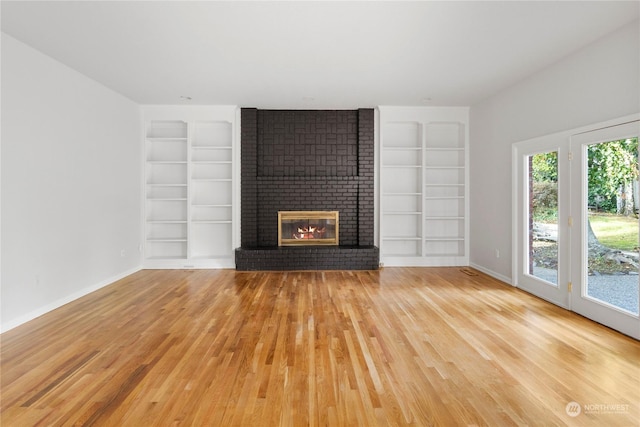 6613 Villa Madera Dr SW, Lakewood, WA 98499 - unfurnished living room featuring built in features, a fireplace, and light hardwood / wood-style floors