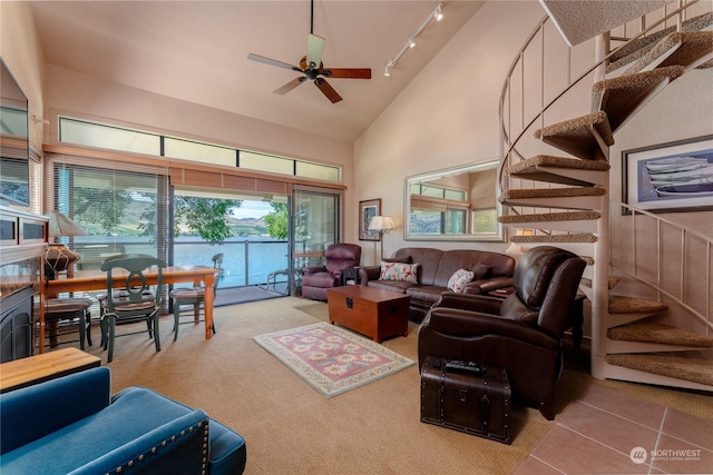 living room with tile patterned flooring, ceiling fan, rail lighting, and high vaulted ceiling