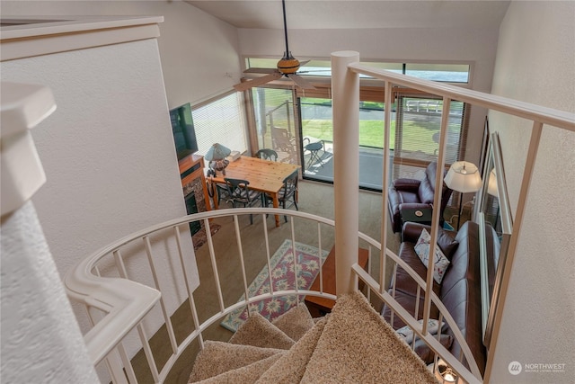 stairs featuring ceiling fan