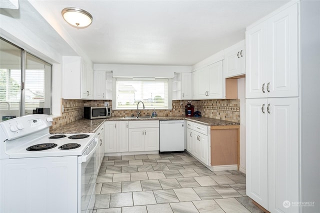 kitchen featuring decorative backsplash, white cabinetry, sink, and white appliances