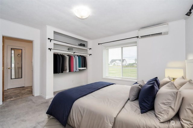 carpeted bedroom with a wall mounted air conditioner and a closet