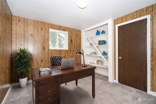 carpeted home office with wood walls and built in features