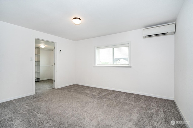 carpeted spare room with an AC wall unit