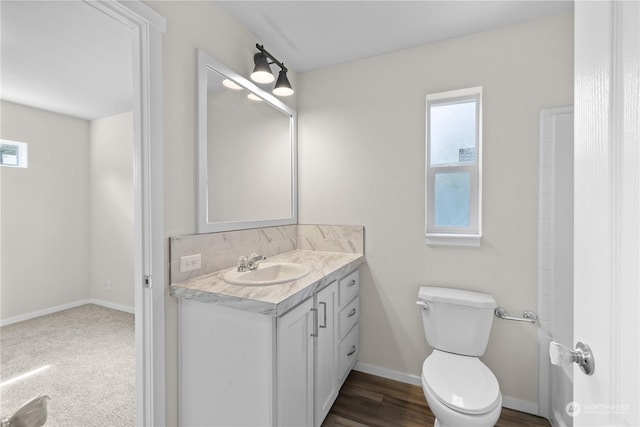 bathroom featuring vanity, plenty of natural light, and toilet