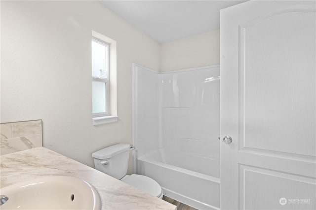 full bathroom with hardwood / wood-style flooring, vanity, shower / bathtub combination, and toilet