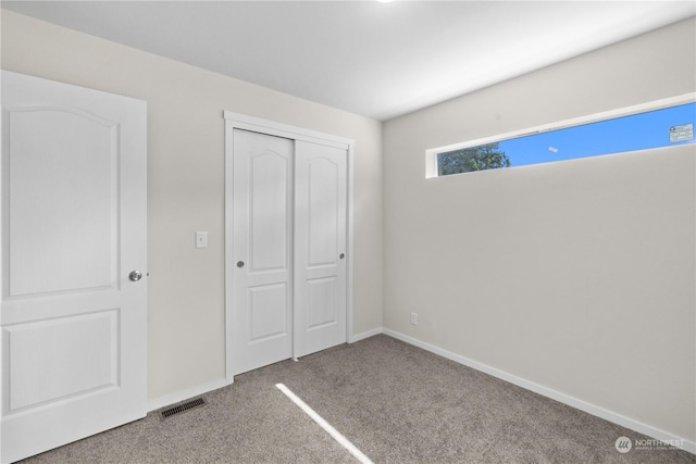 unfurnished bedroom with carpet flooring and a closet