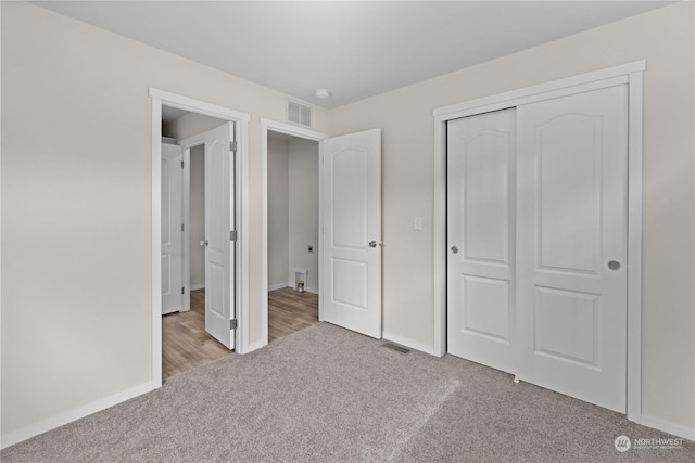 unfurnished bedroom featuring a closet and light carpet