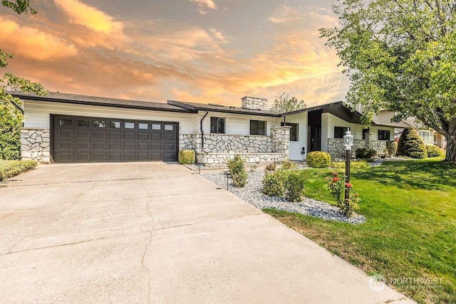 single story home with a garage and a yard