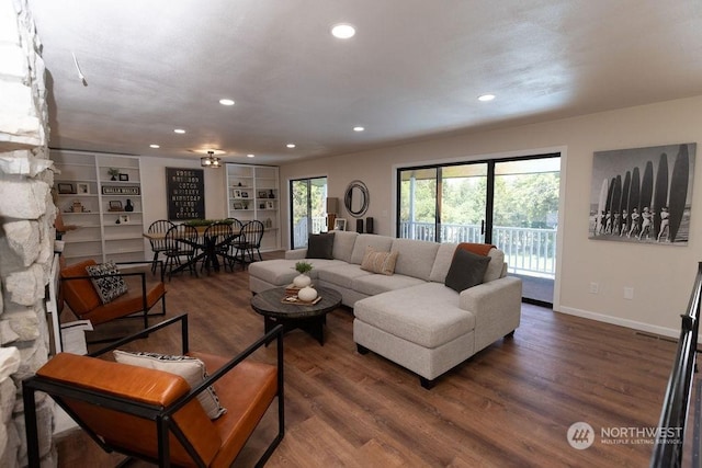 living room featuring dark hardwood / wood-style flooring and built in shelves