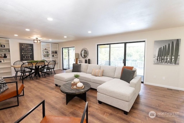 living room with hardwood / wood-style flooring and built in features