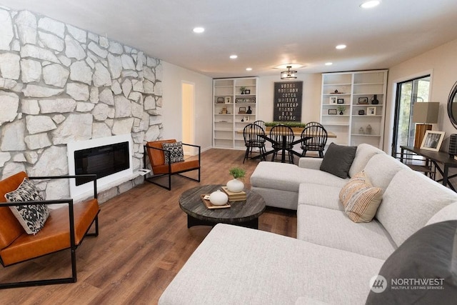 living room featuring a stone fireplace and hardwood / wood-style floors