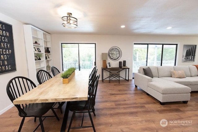 dining area featuring hardwood / wood-style flooring, a wealth of natural light, and a chandelier