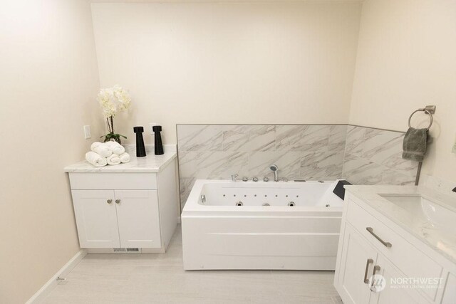 bathroom featuring tile patterned flooring, vanity, and a washtub