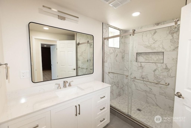 bathroom featuring vanity and a shower with door