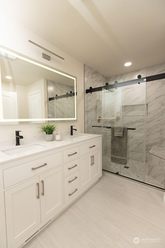 bathroom featuring a shower with door and vanity