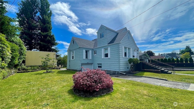 view of property exterior featuring a yard, roof with shingles, and stairway