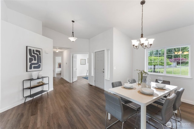 dining space with baseboards, dark wood finished floors, and a notable chandelier