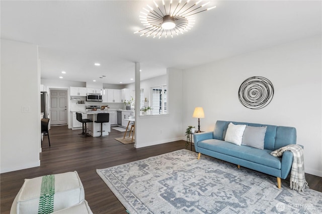 living area with recessed lighting, baseboards, an inviting chandelier, and dark wood-style floors