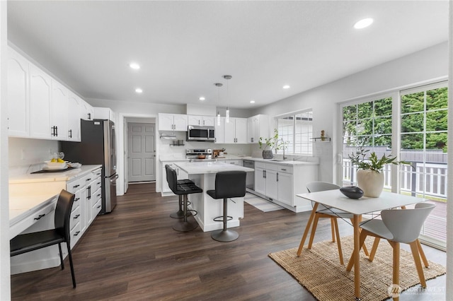 kitchen featuring recessed lighting, a kitchen breakfast bar, a kitchen island, and stainless steel appliances