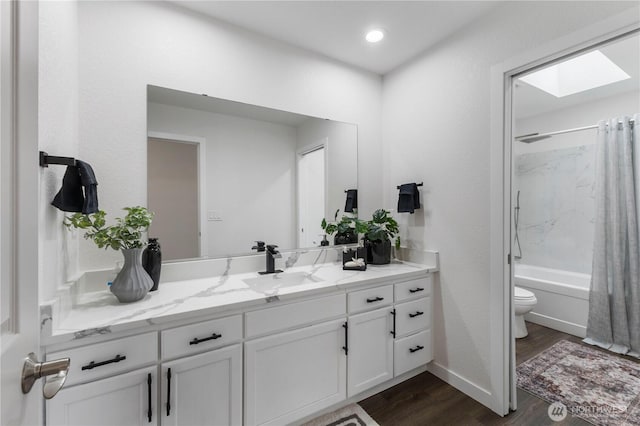 full bath featuring vanity, wood finished floors, toilet, recessed lighting, and shower / tub combo