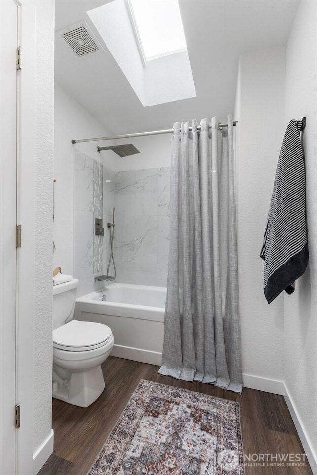 full bathroom with visible vents, wood finished floors, toilet, shower / bath combo, and a skylight