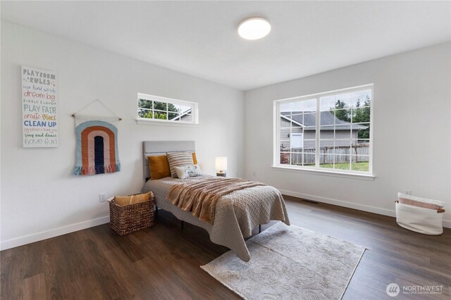 bedroom featuring baseboards, wood finished floors, and visible vents