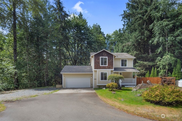 view of front of house featuring a garage, aphalt driveway, fence, a porch, and a front yard