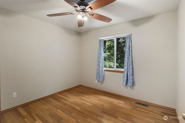 empty room with visible vents, light wood-style flooring, and baseboards