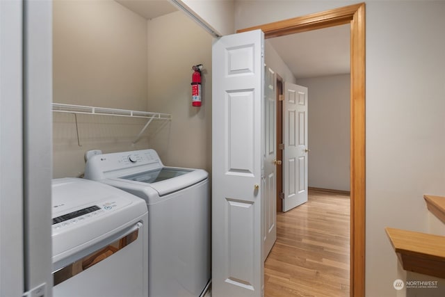 laundry area with laundry area, independent washer and dryer, and light wood-style floors