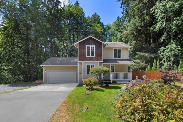 traditional-style home with concrete driveway, fence, a front lawn, and a garage