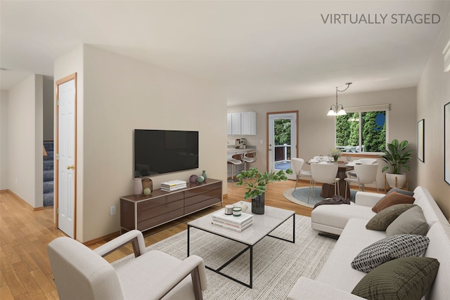 living area with baseboards and light wood-style flooring