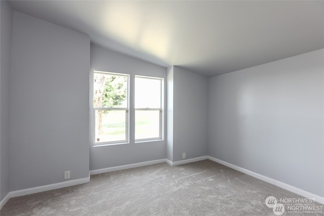 empty room with lofted ceiling and carpet flooring