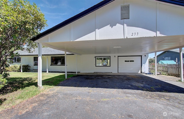 view of front of home with a carport, a garage, and a front lawn