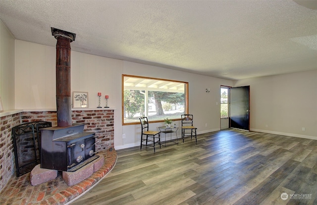 living room with hardwood / wood-style flooring, a textured ceiling, and a wood stove