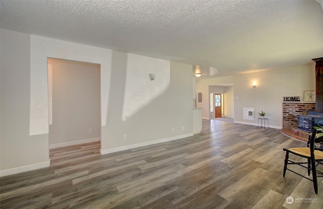 living room with hardwood / wood-style flooring, a textured ceiling, and a wood stove