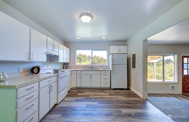 kitchen with sink, white appliances, wood-type flooring, and white cabinets