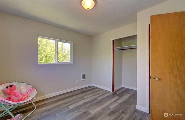 unfurnished bedroom featuring hardwood / wood-style flooring and a textured ceiling