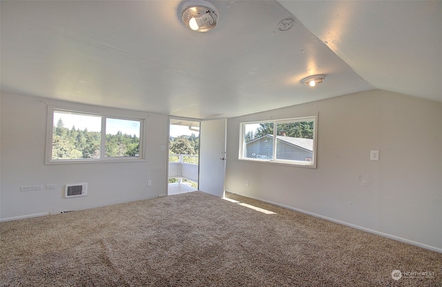 carpeted spare room with lofted ceiling