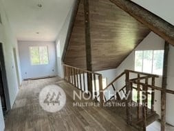 additional living space with hardwood / wood-style flooring and vaulted ceiling