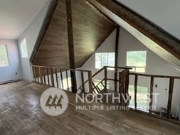 additional living space with hardwood / wood-style flooring