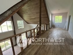 bonus room featuring a wealth of natural light, lofted ceiling, and dark wood-type flooring