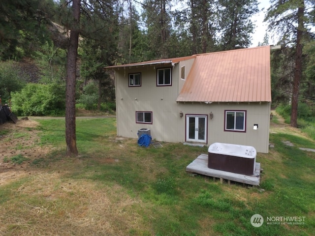 back of property with french doors and a lawn