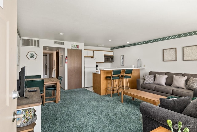 living room with light carpet, recessed lighting, and visible vents