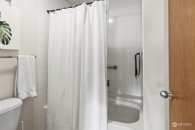 bathroom featuring toilet and shower / bath combination with curtain