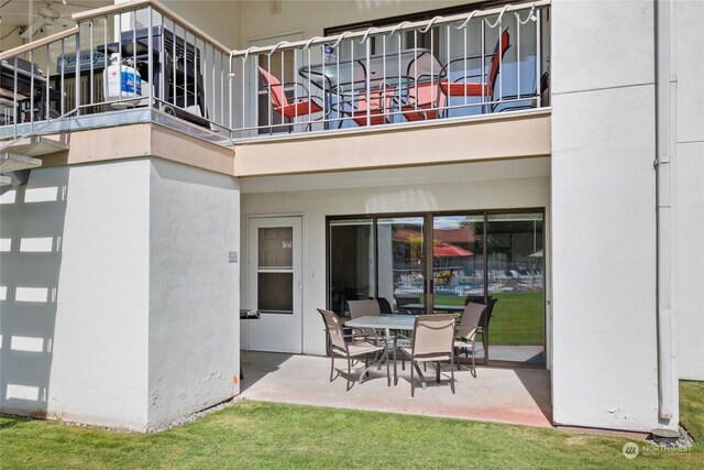 exterior space with a patio, a balcony, and stucco siding