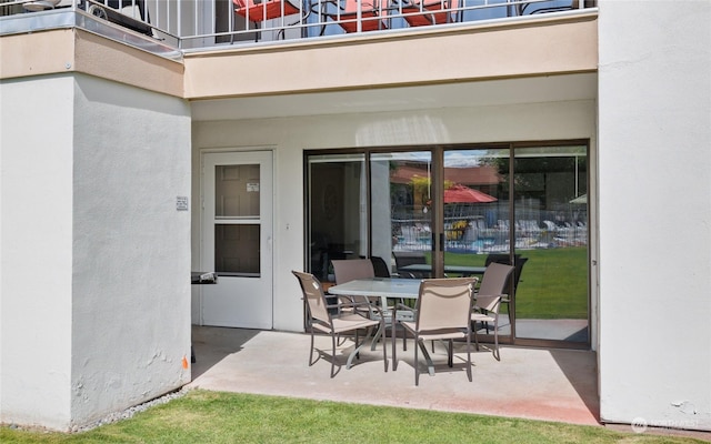 view of patio with outdoor dining space and a balcony