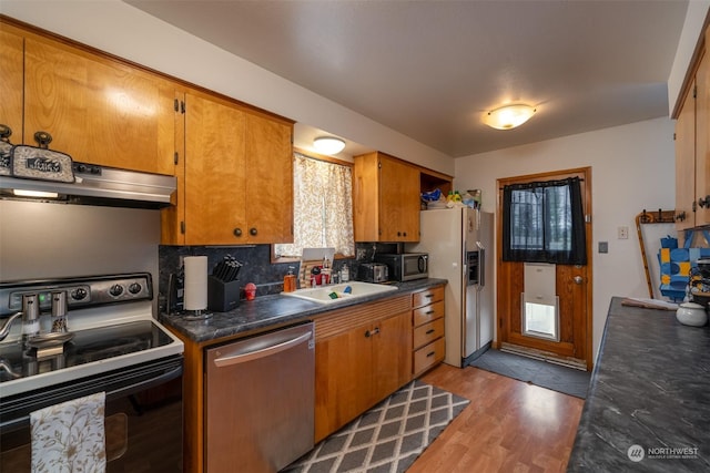 kitchen featuring tasteful backsplash, sink, hardwood / wood-style flooring, and stainless steel appliances