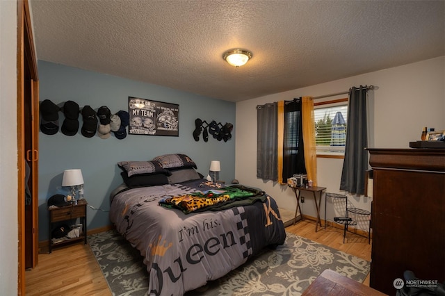 bedroom featuring a textured ceiling and light wood-type flooring