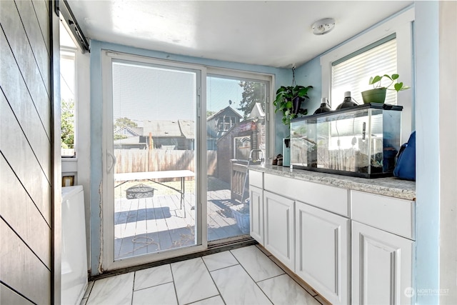 doorway to outside with light tile patterned floors